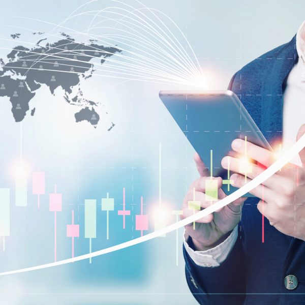 Double exposure of businessman using the tablet with cityscape and financial graph on blurred building background, Business Trading concept.